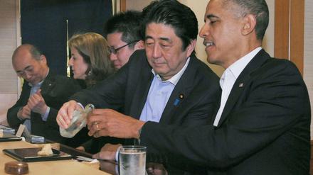 Japans Premier Abe schenkt Obama Reiswein ein.