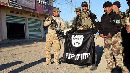 Irakische Soldaten (hier mit einer Flagge des IS) haben die Stadt Ramadi zurückerobert. Doch die Kämpfe gehen weiter. 