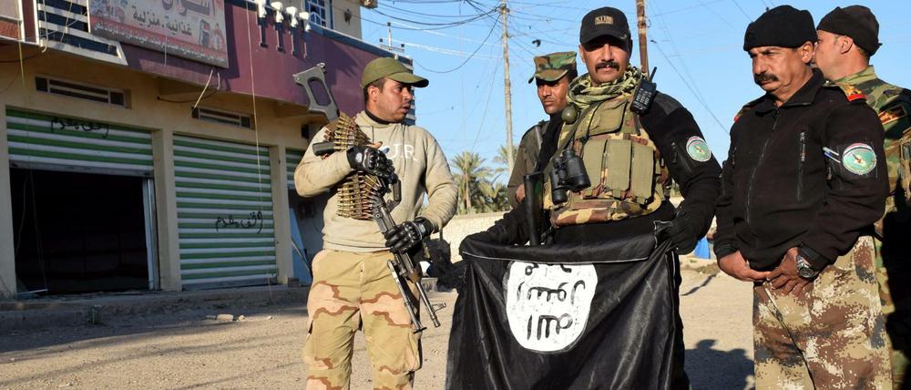 Irakische Soldaten (hier mit einer Flagge des IS) haben die Stadt Ramadi zurückerobert. Doch die Kämpfe gehen weiter. 