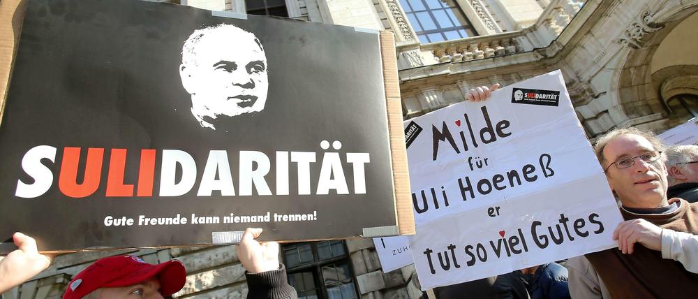 Fans halten zum Prozessauftakt vor dem Landgericht München Transparente mit der Aufschrift "Sulidarität" und "Milde für Uli Hoeneß" in die Höhe.