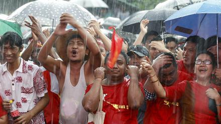 Freude im Regen. Anhänger von Aung San Suu Kyis Oppositionspartei NLD feiern die ersten Teilergebnisse der Parlamentswahl in Myanmar. 