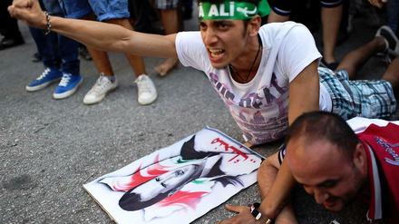 Syrische Demonstranten liegen vor einem Bild des syrischen Präsidenten Assad auf dem Boden. Sie protestieren gegen den geplanten Militäreinsatz der USA.