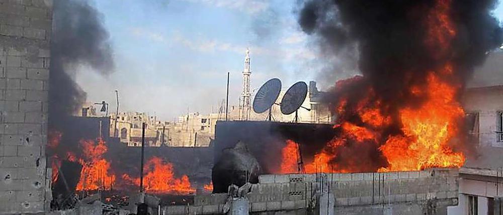 Dichter Qualm steigt aus brennenden Häusern in Homs auf. Seit einem Jahr kämpft Assad gegen eine Protestbewegung, die trotz Milizenterror, Folter und Artilleriebeschuss nicht aufgibt.
