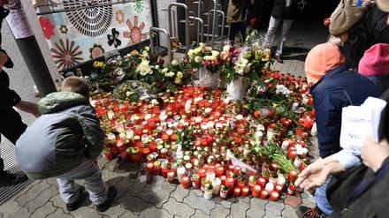 Kerzen und Blumen werden zum Gedenken an das 15-jährige Opfer am Drogeriemarkt in Kandel abgelegt.