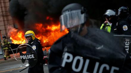 Proteste in Washington: Polizisten vor einem brennenden Auto