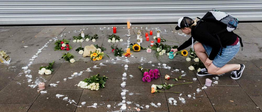 Eine Frau drückt am Tatort in Hamburg ihre Trauer aus.