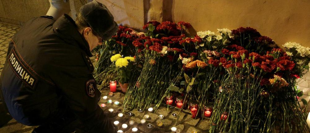 Ein russischer Polizist entzündet eine Kerze zum Gedenken an die Toten des U-Bahn-Anschlags.