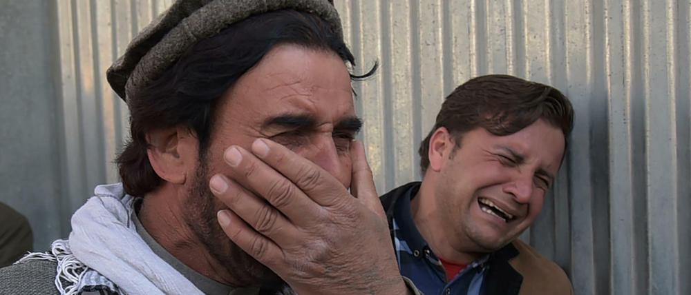 Zwei afghanische Männer trauern um Verwandte, die bei einem Terroranschlag in Kabul getötet wurden.