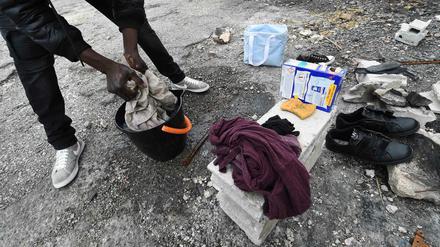Ein Flüchtling - hier nicht in Ungarn, sondern am Rande von Marseille - wäscht in einem Eimer auf der Straße seine Wäsche. 