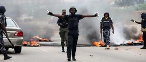 Nigerianische Polizisten greifen bei Protesten in Abuja ein.
