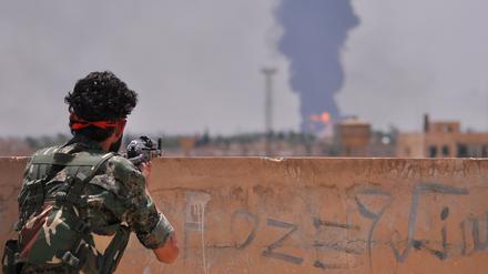 Ein kurdischer YPG-Kämpfer blickt auf die ebenfalls umkämpfte Stadt Hasakeh in Nordsyrien.