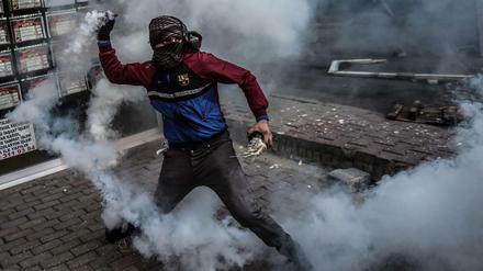 Ein kurdischer Demonstrant schleudert eine Gas-Kartusche auf türkische Polizisten. Die gewalttätigen Proteste schaden den Chancen der kurdischen HDP-Partei.