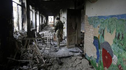Ein ukrainischer Soldat in einer zerstörten Schule im Dorf Pisky in der Nähe der ostukrainischen Stadt Donezk. Nach UN-Angaben wurden in der Ostukraine etwa 200 Schulen bei den Kämpfen zerstört oder beschädigt.