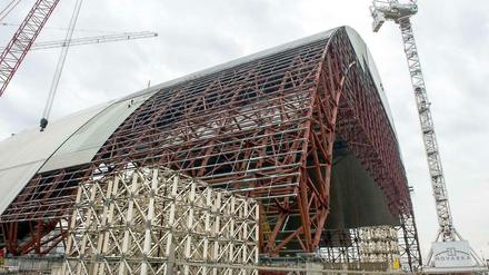 Diese gigantische Traglufthalle aus Stahl soll über den havarierten Reaktor vier des Atomkraftwerks Tschernobyl geschoben werden, und die dort lagernden rund 1,5 Tonnen strahlenden Staubs etwa 100 Jahre halbwegs sicher einschließen. Fertig ist der Bau frühestens 2017. 