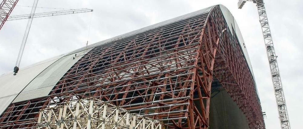 Diese gigantische Traglufthalle aus Stahl soll über den havarierten Reaktor vier des Atomkraftwerks Tschernobyl geschoben werden, und die dort lagernden rund 1,5 Tonnen strahlenden Staubs etwa 100 Jahre halbwegs sicher einschließen. Fertig ist der Bau frühestens 2017. 