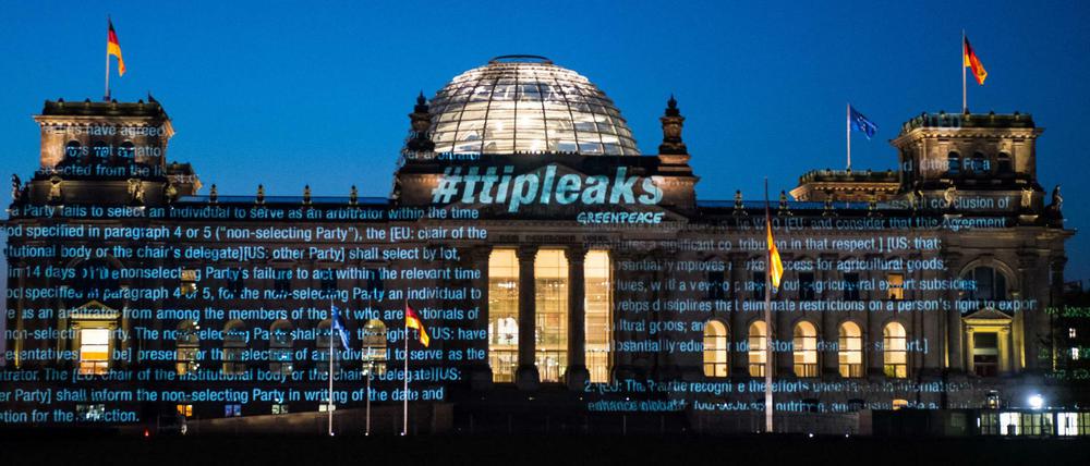 Aktivisten der Umweltorganisation Greenpeace projizieren am frühen Morgen des 02.05.2016 Teile des bisher geheimen Verhandlungstextes und den Schriftzug #ttipleaks auf die Fassade des Reichstagsgebäudes in Berlin, den Sitz des Deutschen Bundestages. 