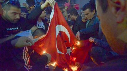 Vor der türkischen Botschaft in Athen verbrennen armenische Demonstranten eine türkische Flagge.