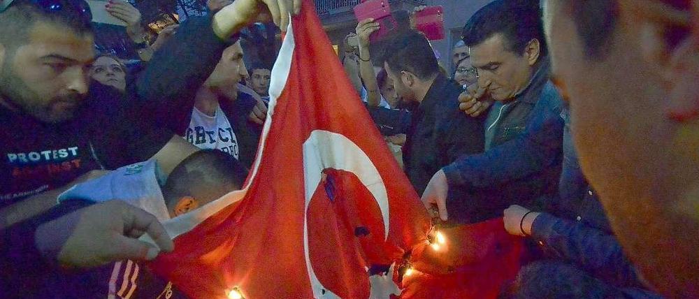 Vor der türkischen Botschaft in Athen verbrennen armenische Demonstranten eine türkische Flagge.