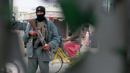 Ein Mitglied der afghanischen Sicherheitskräfte sichert am Dienstag, den 8. Dezember 2015 das Gebiet um eine Polizeistation, die von Taliban angegriffen wurde. Gleichzeitig wurde offenbar der Flughafen von Kandahar von Taliban erobert. 