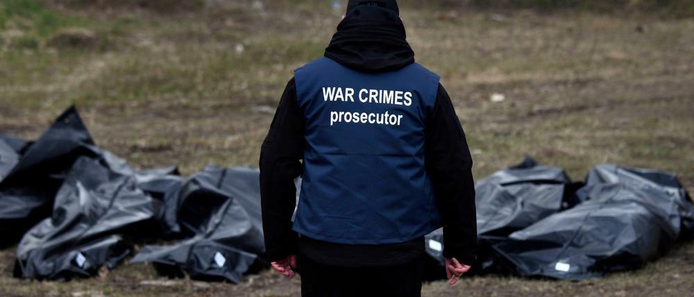 Ein Ermittler in Butscha trägt eine Weste mit der Aufschrift „War Crimes Prosecutor“ („Ankläger für Kriegsverbrechen“).