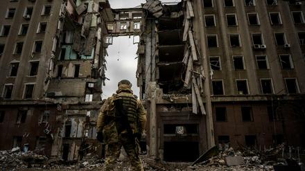 Ein ukrainischer Soldat steht vor einem zerstörten Gebäude in Mykolajiw.