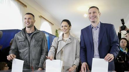 Vitali (r.), seine Frau Natalya und sein Bruder Wladimir Klitschko bei der Stimmabgabe. 