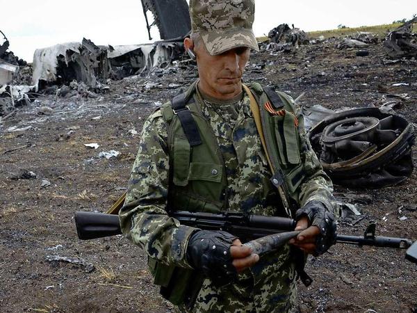 Ein Soldat untersucht die Überreste der abgeschossenen ukrainischen Militärmaschine in der Nähe des Flughafens von Lugansk in der Ostukraine. 