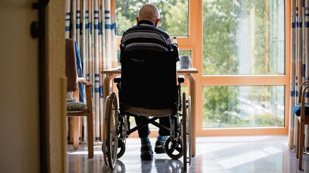 Ein an den Rollstuhl gebundener Bewohner sitzt in einem Altenpflegeheim in seinem Zimmer. 