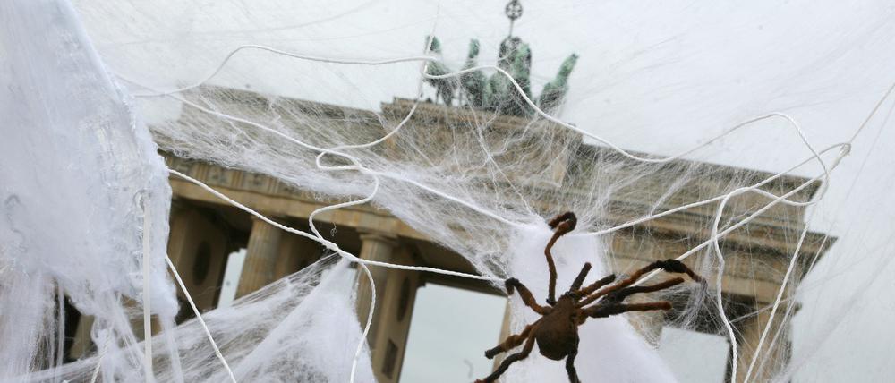 Bei einem Aktionstag gegen Vorratsdatenspeicherung vor dem Brandenburger Tor in Berlin sitzen künstliche Spinnen im Netz.