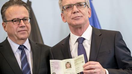Bundesinnenminister Thomas de Maiziere (CDU) zeigt am 09.12.2015 in Berlin den neuen Flüchtlingsausweis neben dem Leiter des Bundesamts für Migration und Flüchtlinge, Frank-Jürgen Weise. 