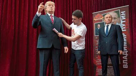 Ein Ausstellungsmitarbeiter entfernt in Sofia (Bulgarien) Fussel von einer Wachsfigur, die US-Präsident Donald Trump (l) darstellen soll. Rechts eine Wachsfigur von Wladimir Putin. 