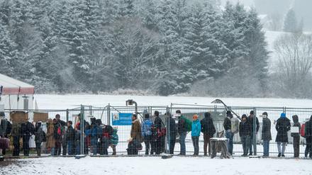 Flüchtlinge warten am Sonntag an der deutsch-österreichischen Grenze nahe Hanging (Österreich) im Schnee vor einem beheizten Zelt. Die Anzahl der Flüchtlinge nach Deutschland wird im November einen neuen Rekord erreichen.