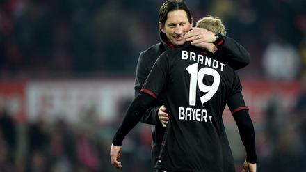 Leverkusens Trainer Roger Schmidt (l) umarmt nach Spielende Julian Brandt (r). 