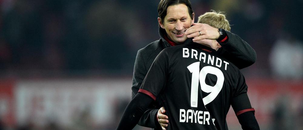 Leverkusens Trainer Roger Schmidt (l) umarmt nach Spielende Julian Brandt (r). 