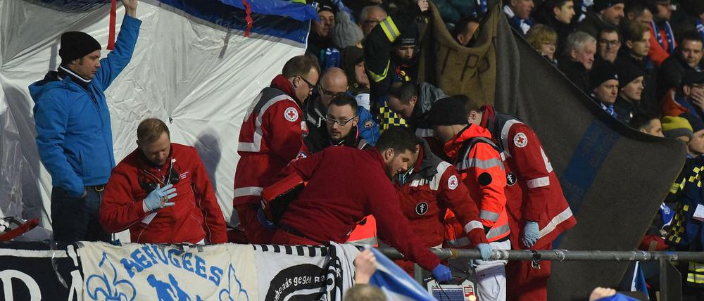 Sanitäter kümmern sich um den zusammengebrochenen Fan von Darmstadt 98.