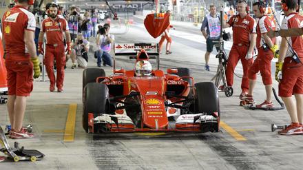 Sebastian Vettel mit seinem Ferrari in der Box.