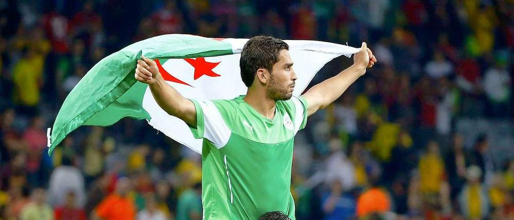 Ins Achtelfinale gesegelt. Die Algerier Essaid Belkalem (o.) und Abdelmoumene Djabou feiern den WM-Erfolg mit Fahnen.