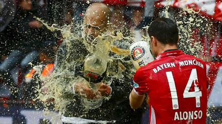 Bier um Bier. Bayerns Xabi Alonso und Trainer Pep Guardiola (links) duschen sich ab.