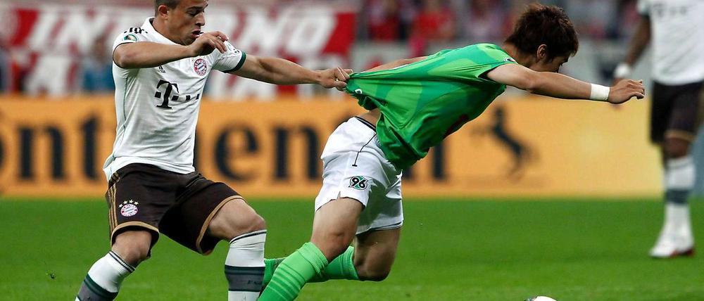 Hier geblieben. Bayern Münchens Xherdan Shaqiri (links) gegen Hiroki Sakai.