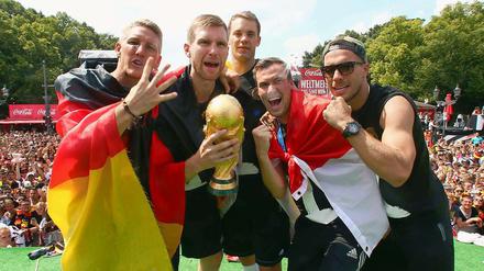 Per Mertesacker (Mitte) hält den WM-Pokal in den Händen.
