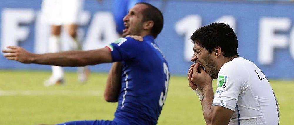 Szene der WM. Luis Suarez (r.) hält sich die Zähne, Giorgio Chiellini die Schulter.