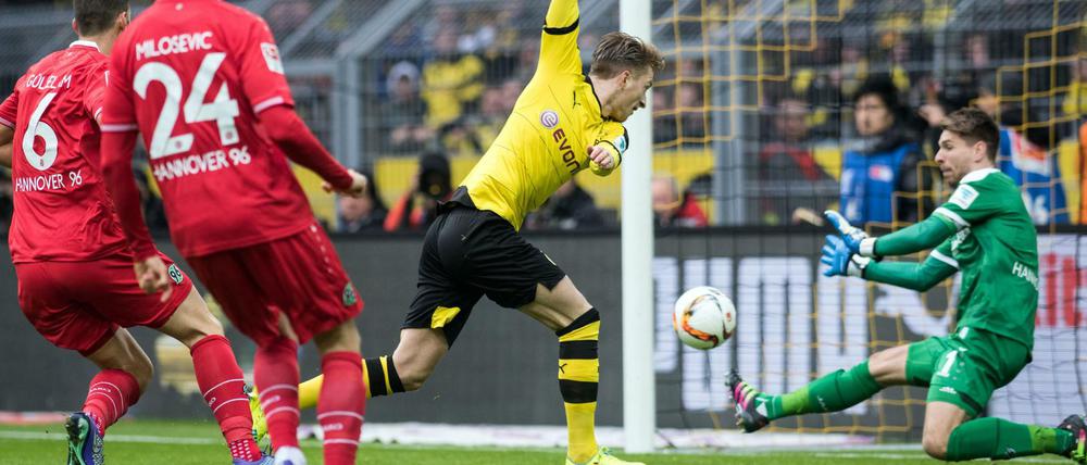 Dortmunds Marco Reus (M) und Torhüter Ron-Robert Zieler von Hannover versuchen an den Ball zu kommen. 