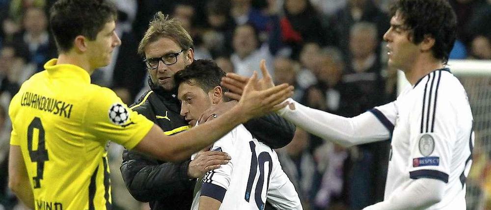 Trost für den "Schalker": BVB-Trainer Jürgen Klopp nimmt sich Mesut Özil zur Brust (hinten), während Robert Lewandowski mit Real Madrids Kaká (r.) abklatscht.