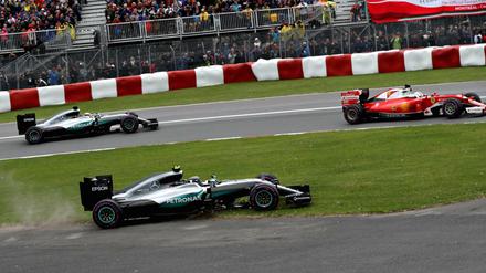 Nico Rosberg (vorne) muss auf die Wiese ausweichen. Sebastian Vettel (rechts) und Lewis Hamilton profitieren.