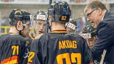 Eishockey-Bundestrainer Pat Cortina mit Spielern. 