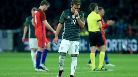 Mario Götze steht nach der Niederlage gegen England auf dem Rasen.