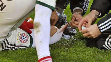 Die Mannschaftsärzte des FC Bayern versorgen die Wunde von Arjen Robben.
