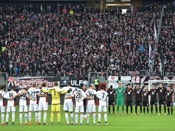 Die Mannschaften von Frankfurt (hinten) und Leverkusen stehen am Mittelkreis zur Schweigeminute für die Terror-Opfer von Paris.