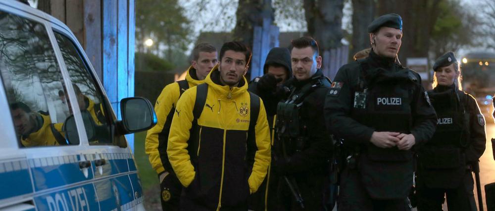 Die BVB-Spieler Nuri Sahin und Matthias Ginter warten nach dem Anschlag auf den Dortmunder Mannschaftbus neben Polizisten. 