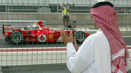 Ein Scheich klatscht 2004 vor dem ersten Formel-1-Rennen in Bahrain auf der Rennstrecke Beifall.